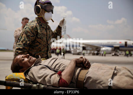 Kathmandu, Nepal. 13th May, 2015. A U.S. Marine helps carry a Nepalese man to a triage area at the Tribhuvan International Airport May 12, 2015 in Kathmandu, Nepal. A 7.3 magnitude aftershock earthquake struck the kingdom following the 7.8 magnitude earthquake on April 25th.
