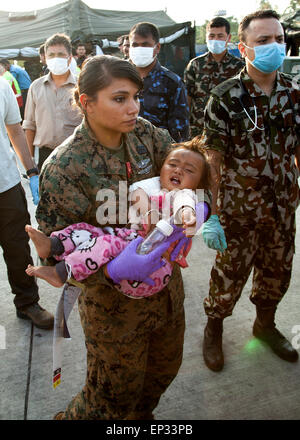 Kathmandu, Nepal. 13th May, 2015. U.S. Navy Petty Officer 2nd Class Jessica Gomez-Hickman holds a young earthquake victim before loading her into an ambulance at a medical triage area setup at Tribhuvan International Airport May 12, 2015 in Kathmandu, Nepal. A 7.3 magnitude aftershock earthquake struck the kingdom following the 7.8 magnitude earthquake on April 25th.