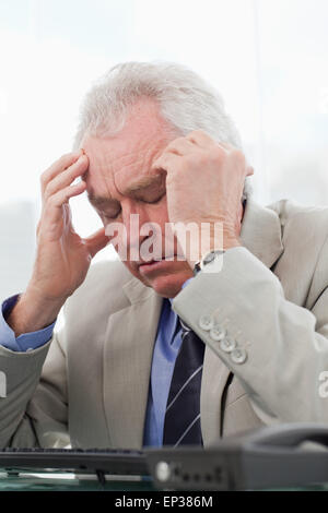 Portrait of an exhausted senior manager having a headache Stock Photo