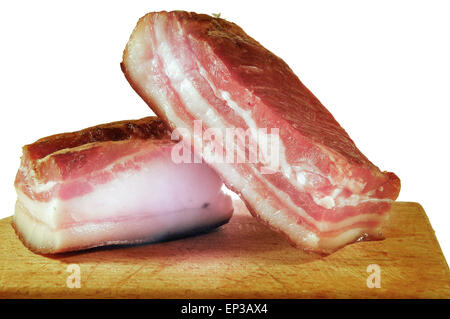 Beautiful two pieces of local bacon on wooden kitchen board. Stock Photo