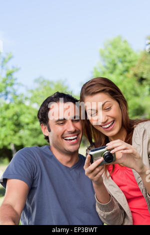 Two friends smiling happily as the look at the photo collection in a camera Stock Photo