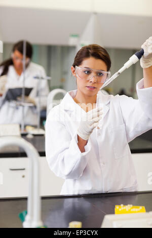 Portrait of a focused student pouring liquid in a tube Stock Photo