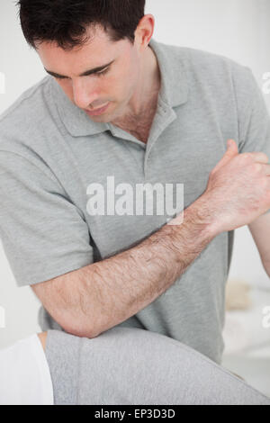 Physiotherapist using his elbow on the hip of a woman Stock Photo