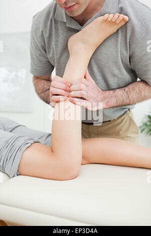 Close-up of a man massaging the leg of a woman Stock Photo