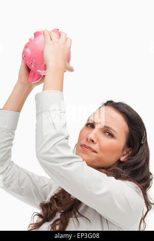 Portrait of a brunette holding an empty piggy bank Stock Photo