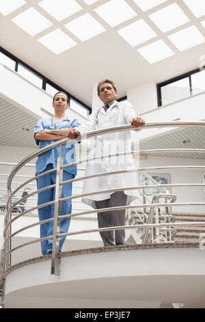 Nurse and doctor standing earnestly at the stairwell Stock Photo