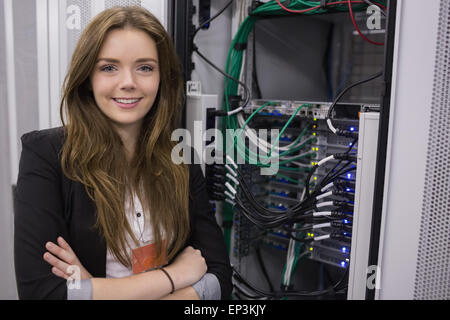 Girl standing in front of rack mounted servers Stock Photo