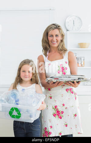 Mother and daughter standing in the kitchen with waste for recycling Stock Photo