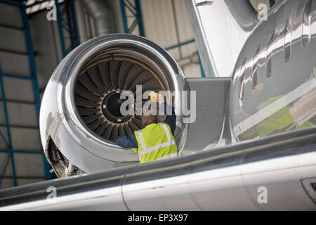 Aircraft mechanic inspecting airplane's jet engine Stock Photo