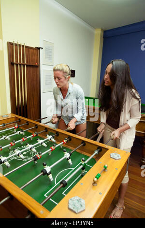 Two women playing table football in a bar, Madeira, Europe Stock Photo