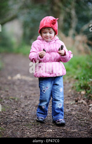 Girl collecting pine cones in the forest Stock Photo