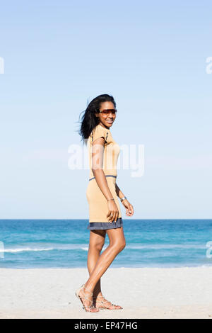 Young stylish woman walking along beach Stock Photo