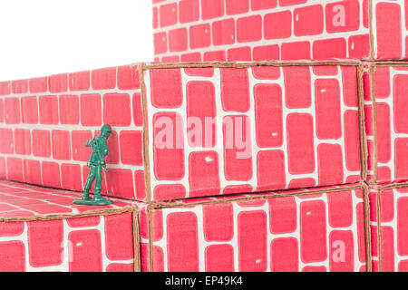 Green army man banging head against a brick wall