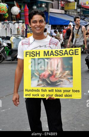 Bangkok, Thailand:  Thai man holding an advertising poster for fish massage on Khao San Road Stock Photo