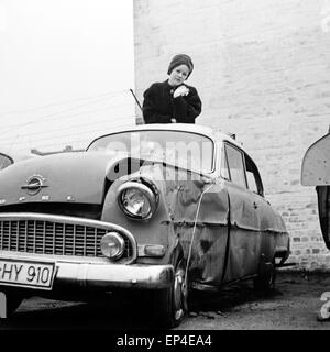 Deutsche Schlagersängerin und Schauspielerin Rica Deus nach einem Unfall mit ihrem Opel, Deutschland 1950er Jahre. German sc Stock Photo