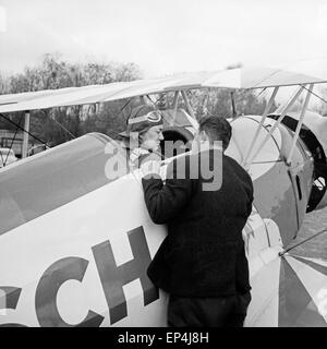 Deutscher Kunstflieger Albert Falderbaum in seinem Bücker Bü 133 Doppeldecker, Deutschland 1960er Jahre. German stunt pilot A Stock Photo
