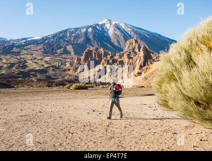 Hiker at el llano de Ucanca in Teide National Park with snow capped mount Teide in background. Tenerife, Canary Islands, Spain Stock Photo