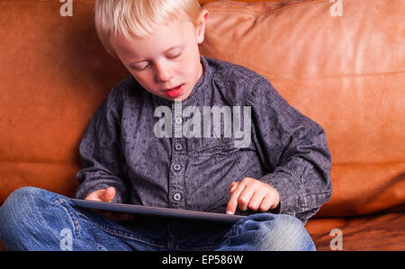 Child with Digital tablet. The Boy play and learn when he is using the tablet Stock Photo