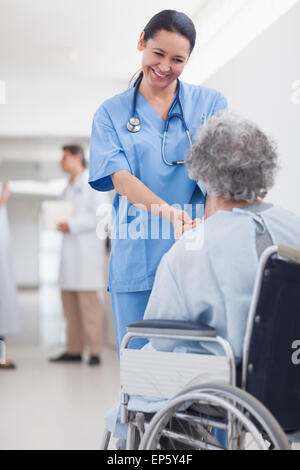 Doctor greeting recovering senior patient in wheelchair Stock Photo