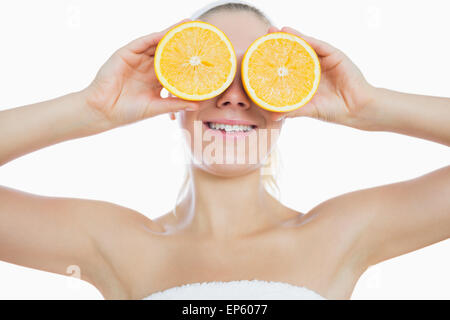 Woman holding slices of orange in front of eyes Stock Photo
