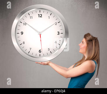 Attractive lady holding a huge clock Stock Photo