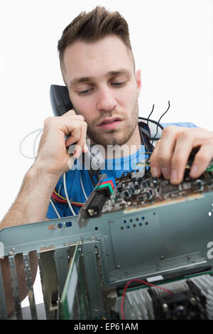 Computer engineer working on sound card on cpu while on call Stock Photo