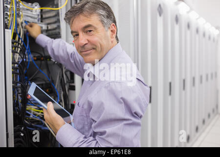 Technician using tablet pc to check the servers Stock Photo