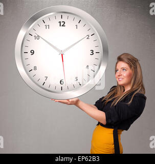 Attractive lady holding a huge clock Stock Photo