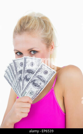 Woman holding fanned banknotes in front of face Stock Photo