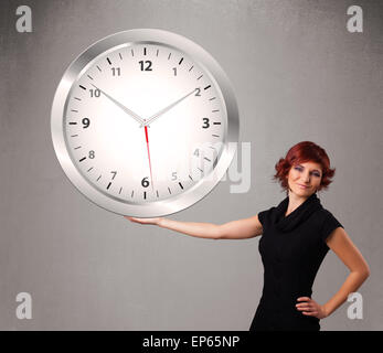 Attractive lady holding a huge clock Stock Photo