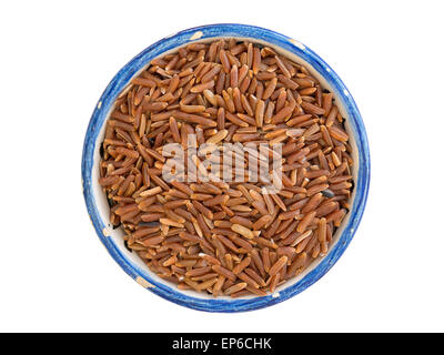 many dry ruby rice corns in small blue cup isolated on white Stock Photo