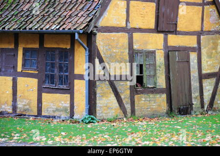 Old worn half-timbered cottage house with broken window