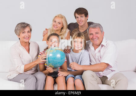 Family portrait looking at camera with a globe Stock Photo