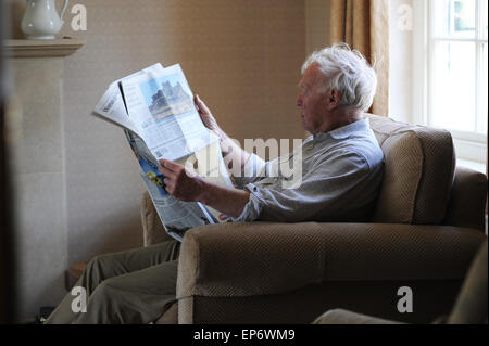Elderly pensioner reading the Daily Telegraph at home in North Yorkshire. Stock Photo