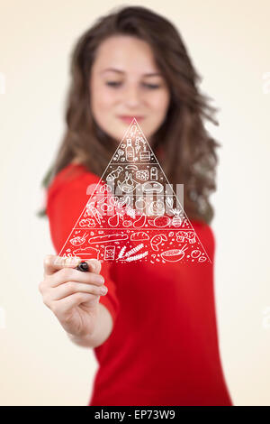 Young woman drawing a food pyramid on whiteboard Stock Photo