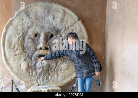 Tourist girl at Bocca della verita, is an image, carved from Pavonazzo marble, of a man-like face, located in the portico of the Stock Photo