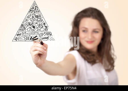 Young woman drawing a food pyramid on whiteboard Stock Photo