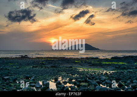 Sunset with Biyangdo island in a cloudy day, view from Hyeopjae beach in Aewol in Jeju Island, Korea. Stock Photo