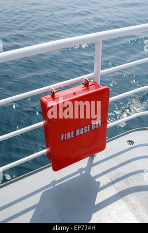 red fire hos box on the banister of a passenger ship Stock Photo
