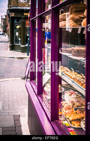 Freshly baked pastries and cakes on display in a patisserie window Stock Photo