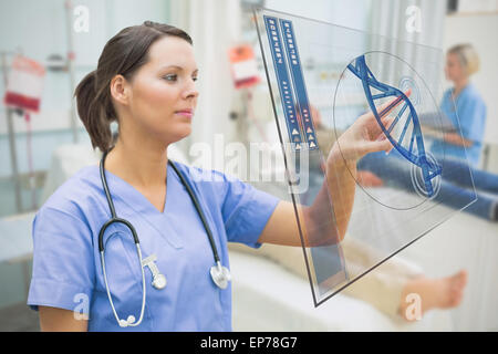 Nurse touching screen displaying blue DNA helix data Stock Photo