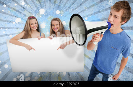 Pretty girls pointing to blank card with young man shouting through megaphone Stock Photo