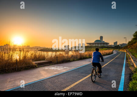 A cyclist rides along the Han River of Seoul, South Korea, in early morning. Stock Photo