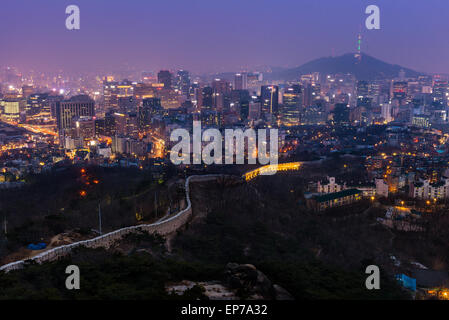 The view over downtown Seoul at dusk from atop Mount Inwangsan. Stock Photo