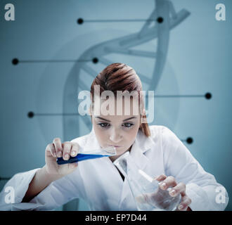 Blonde scientist pouring liquid into erlenmeyer in front of futuristic interface Stock Photo