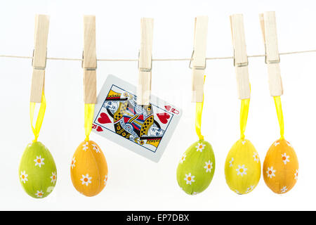 Easter eggs hanging from a line with queen of hearts Stock Photo
