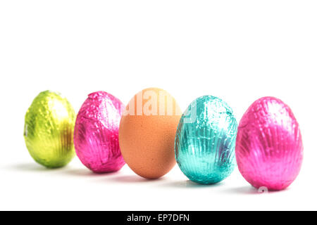 Four easter eggs in a row with one real egg Stock Photo