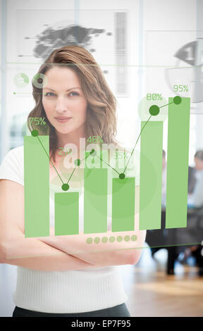Confident blonde businesswoman using green chart interface Stock Photo
