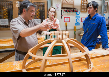 Two students and an explaining teacher in a woodwork class Stock Photo