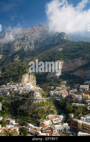Massive mountains dwarf the town of Positano along the Amalfi Coast, Campania, Italy Stock Photo